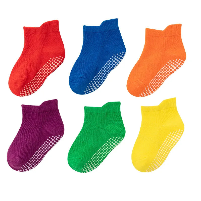 Six pairs of kids anti-slip cotton socks, neatly folded, ready for sale as baby accessories