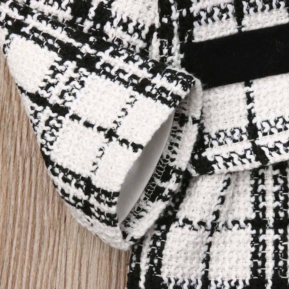 A charming baby girl's winter outfit: warm plaid coat and stylish black tutu dress