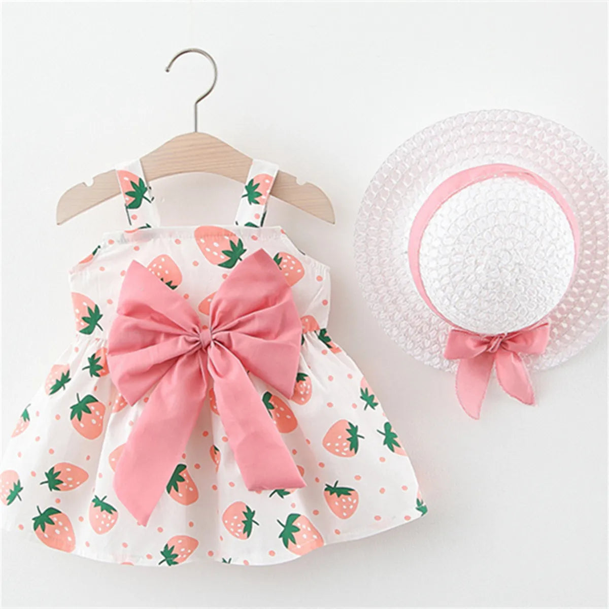 Stylish baby girl's summer dress and sun hat set, featuring a charming red strawberry print.
