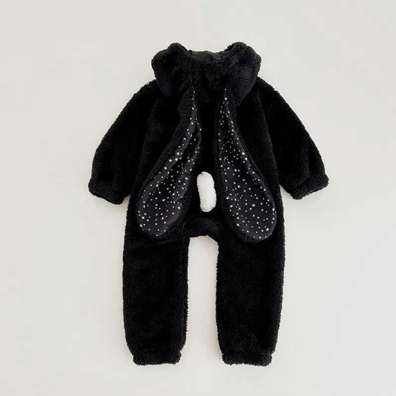 Happy baby sitting in a plush rabbit hooded romper, comfortable and warm newborn outfit.