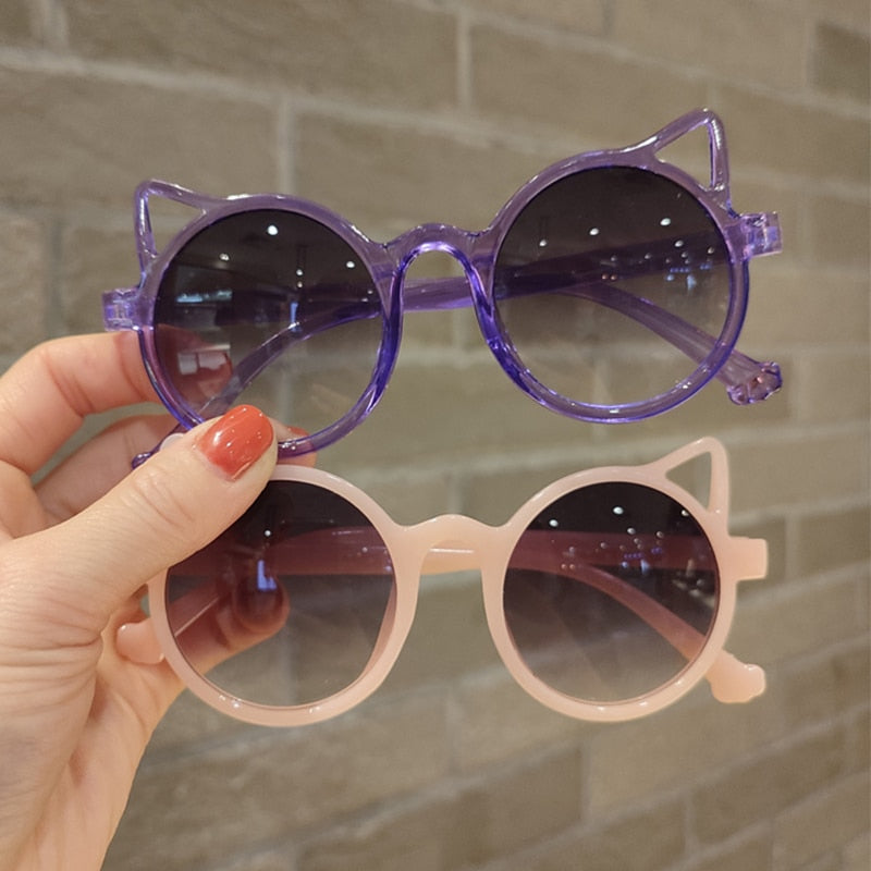 Display of girls' cartoon cat eye sunglasses in multiple hues, UV protection, versatile kids eyewear