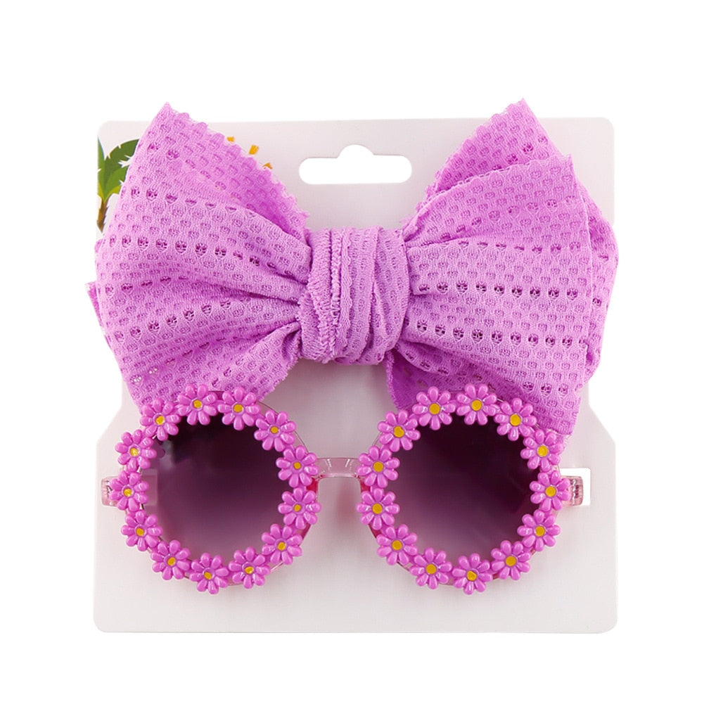 Trendy children's sun protection set: classic blue sunglasses and a striped bow headband.