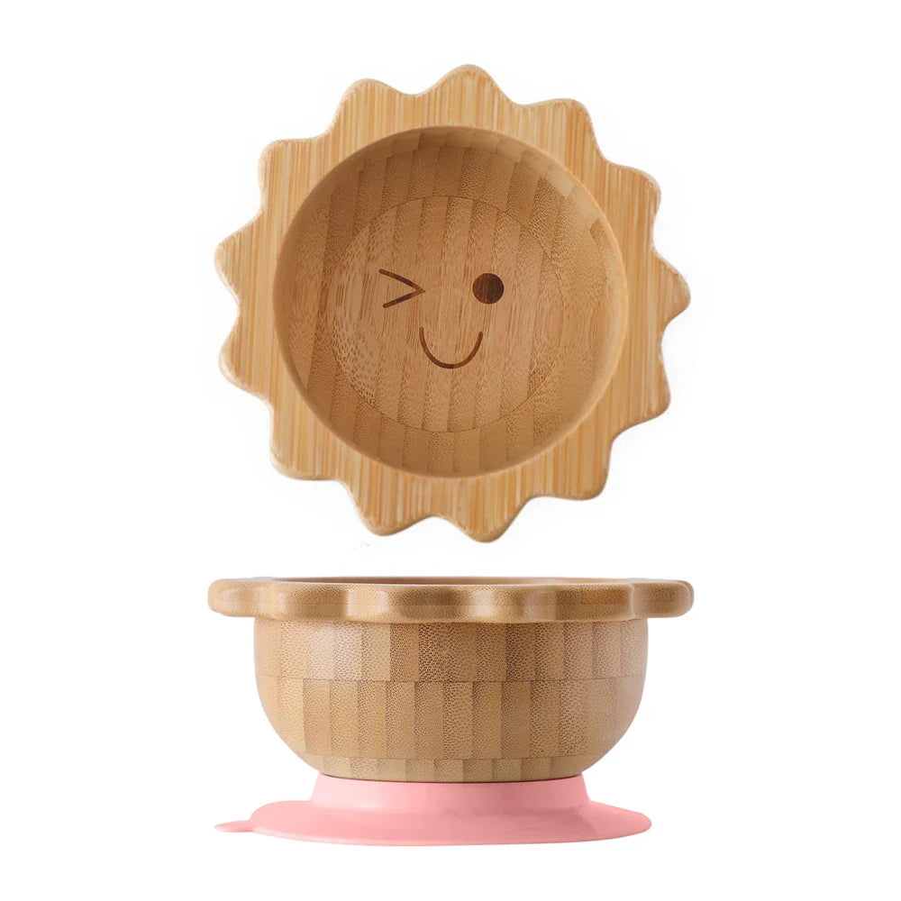 A versatile bamboo suction bowl for infants, featuring a bright pink silicone suction ring for secure grip