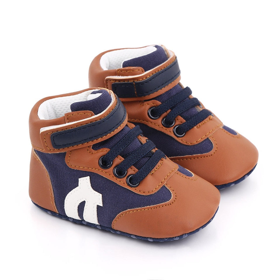 Infant boy's blue canvas hi-cut sneakers, anti-slip soft sole for safe first walking experiences.