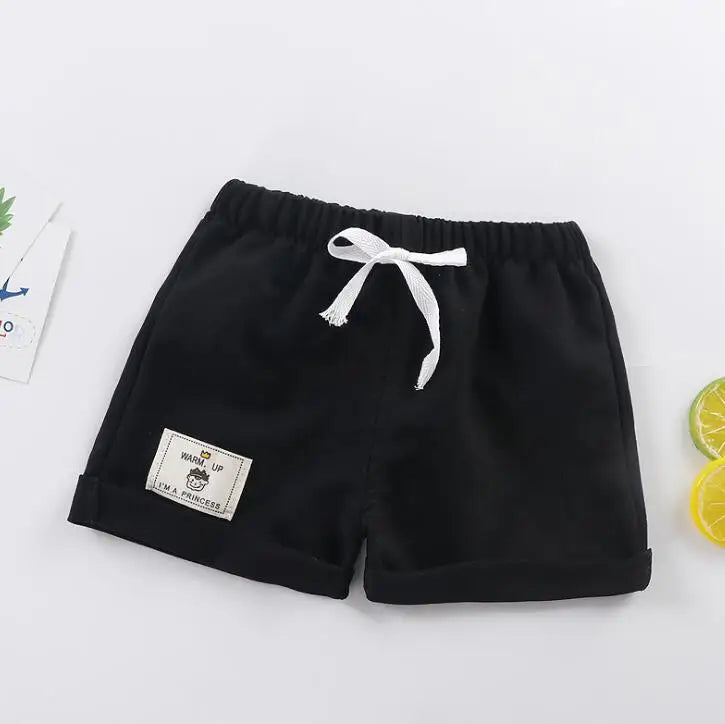 Model shot of a baby boy exploring in comfortable brown casual summer shorts.