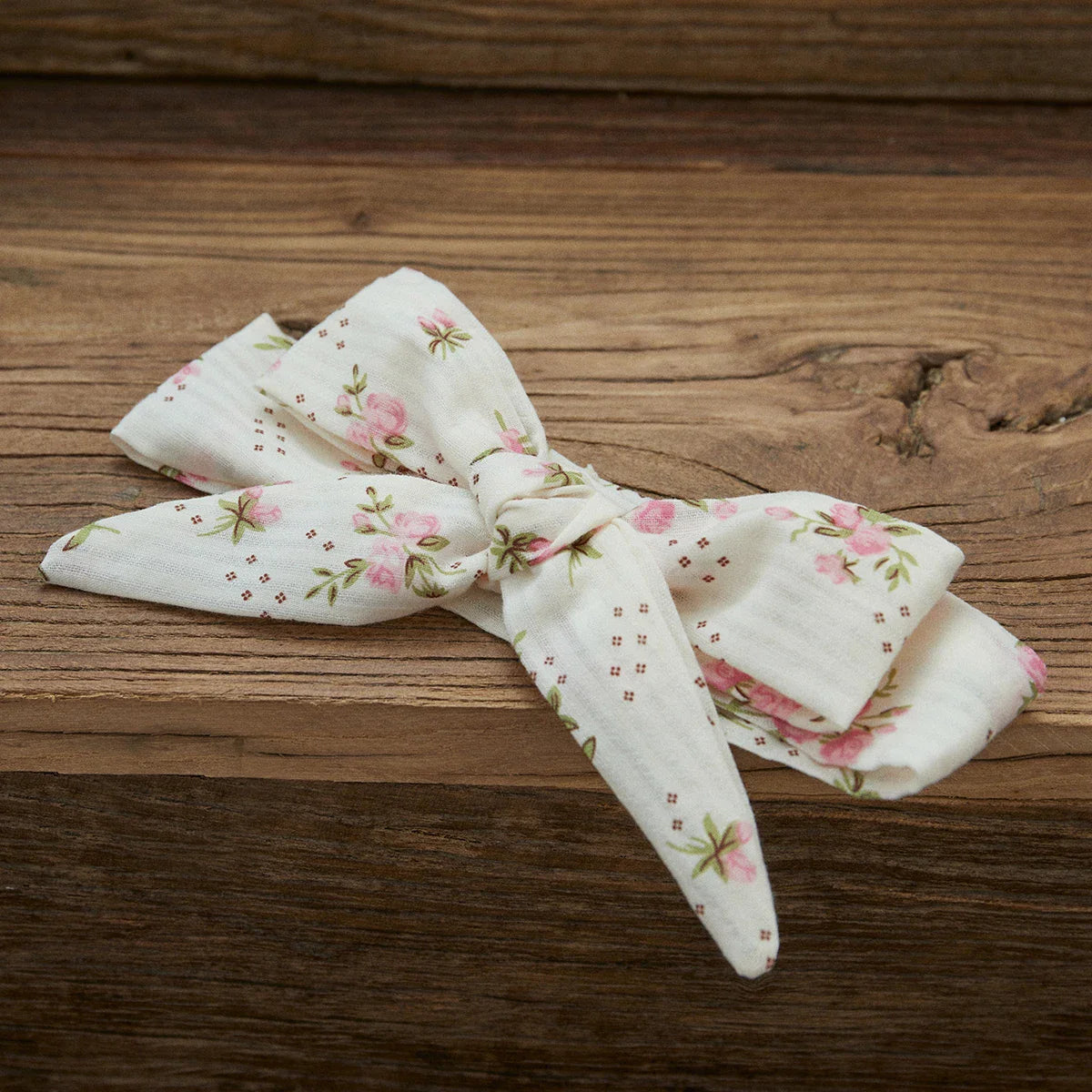 Baby girl wearing a soft cotton blend floral romper and headband set, ideal for warm weather