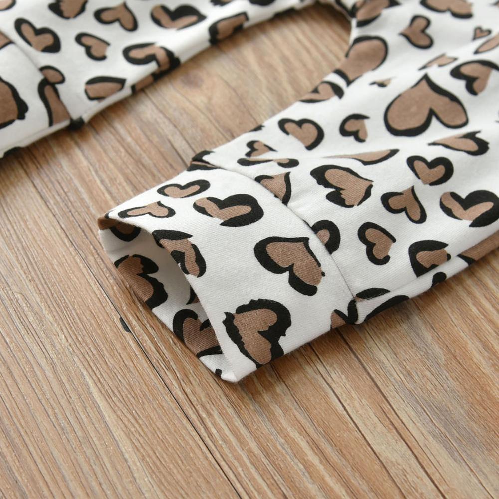 Infant girl's stylish cotton bodysuit with heart pattern, paired with a matching headband.