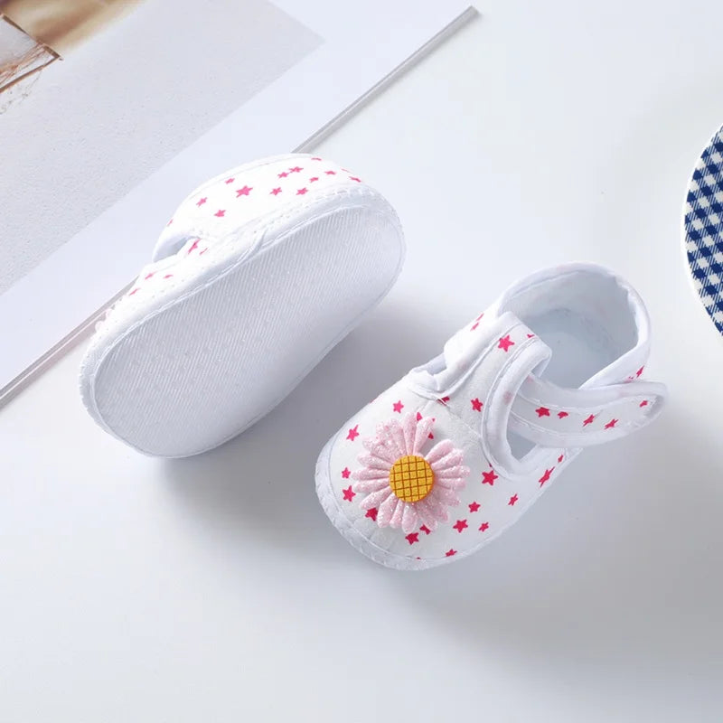 Front view of baby girl's floral soft-soled crib shoes, with an adorable pink bow on top, cute infant shoes.