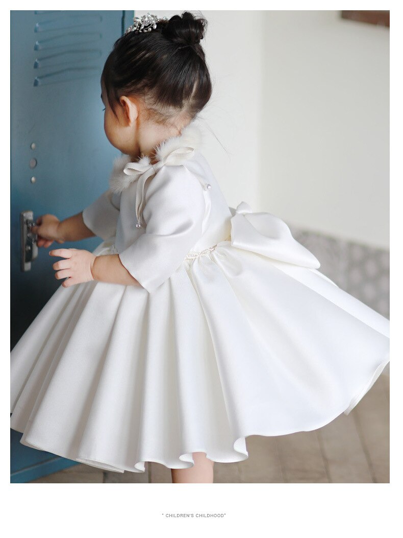 Close-up of pearl white baby special occasion dress, highlighting the soft fabric and half-sleeve design.