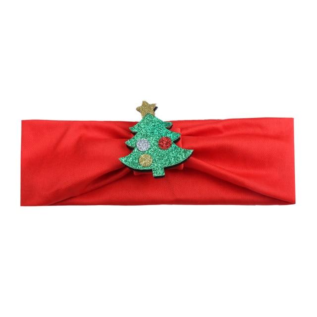 Baby girl in a festive holiday dress wearing a sparkling Christmas tree headband
