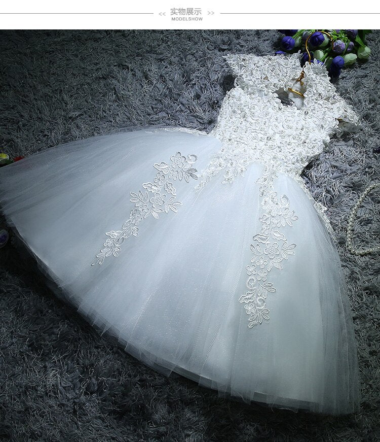 Full-length view of a baby girl dressed in a fancy lace sequin ball gown for special occasions