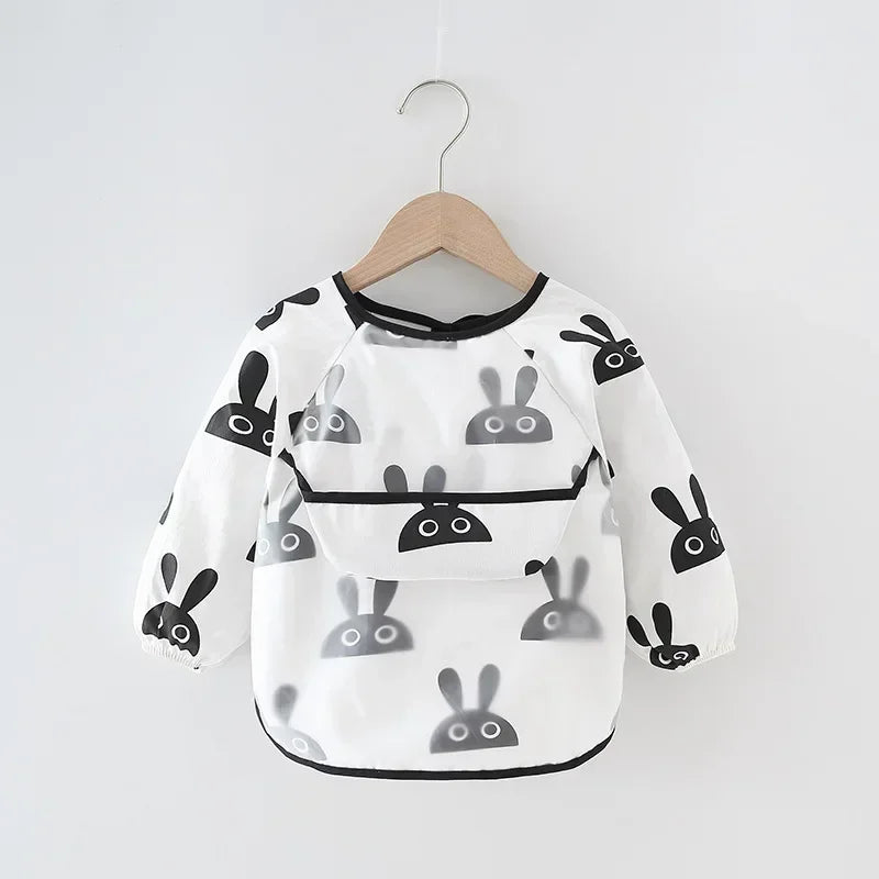 Toddler playing with playdough in a long sleeve waterproof bib, also suitable as an art smock