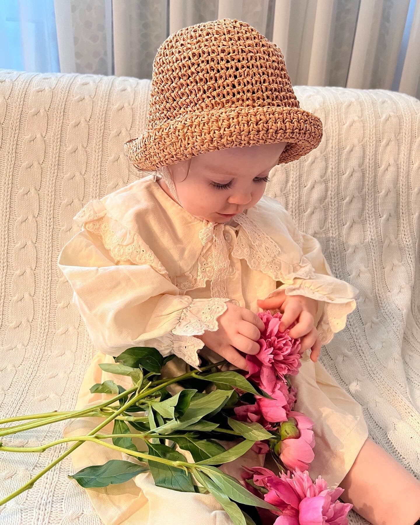 Front view of a simple straw sun protection hat for babies and toddlers, a summer must-have.