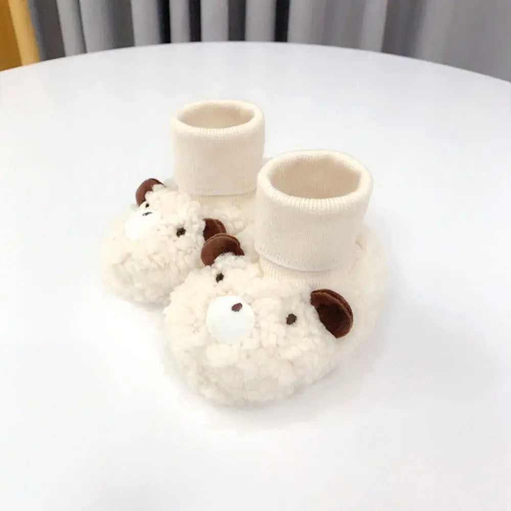 Close-up of cozy baby bear fleece infant slippers, showing detailed texture and soft sole design.