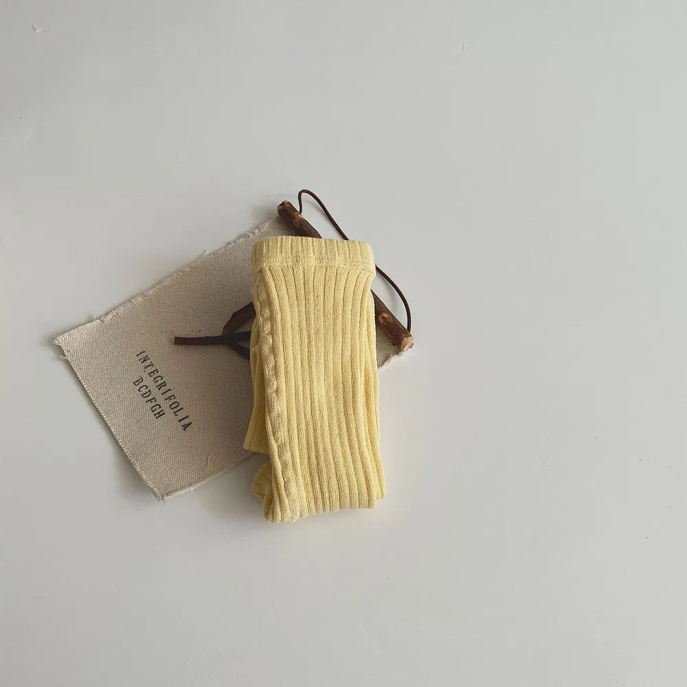Unworn pair of brown cotton knit pantyhose on a flat surface, high-quality children's apparel.