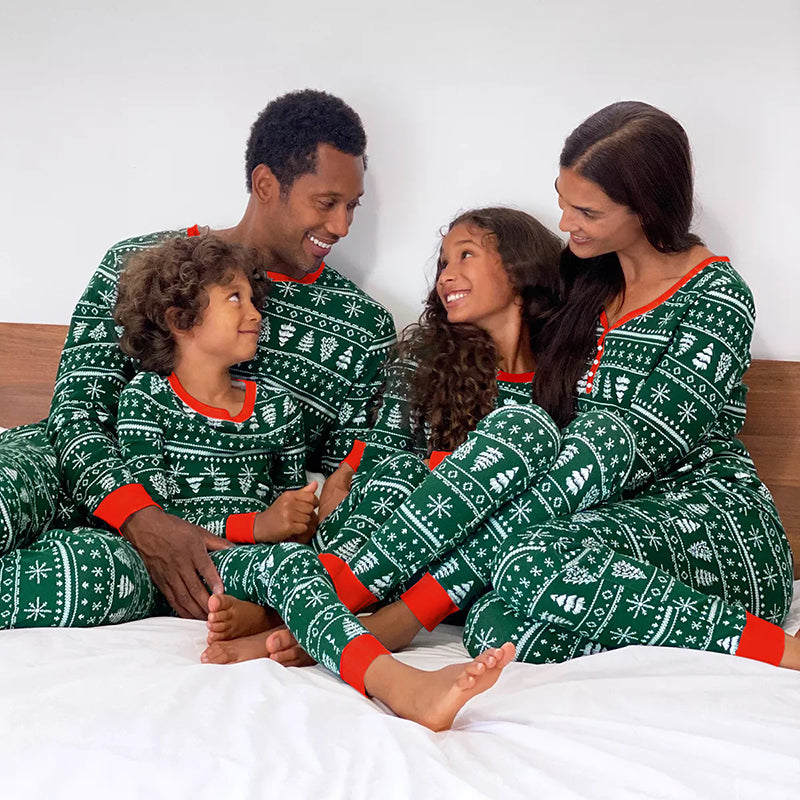 Infant in a cozy family Christmas pajama romper, sleeping peacefully in a crib.