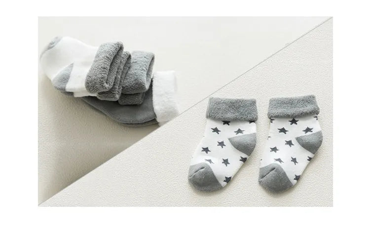 Five pairs of premium cotton unisex baby socks with vibrant cartoon graphics, ensuring comfort.