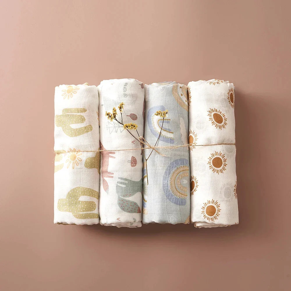 Baby reaching for a crumpled, plush bamboo cotton muslin swaddle blanket on a bed