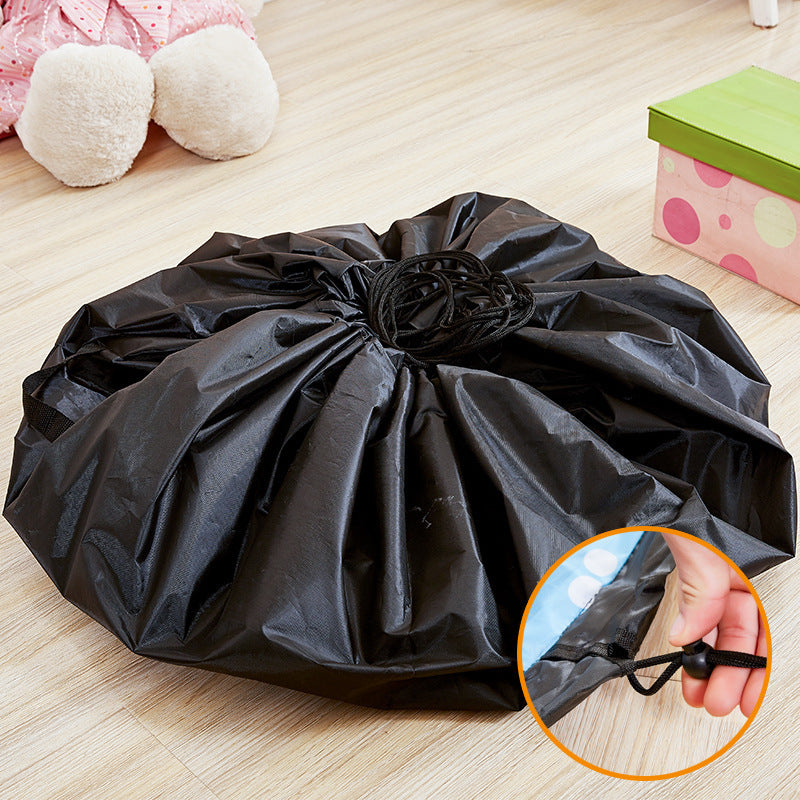 Hand pulling drawstring of 2-in-1 play mat & toy storage bag, transforming it for quick cleanup