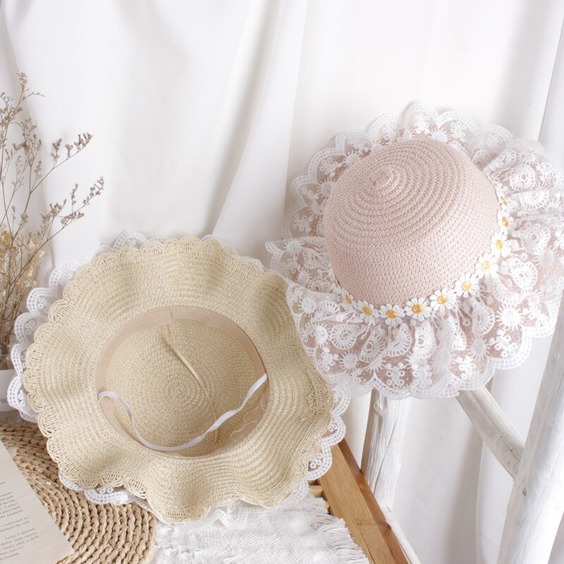 Overhead shot of a kids' sunflower straw hat, featuring a detailed sunflower face design