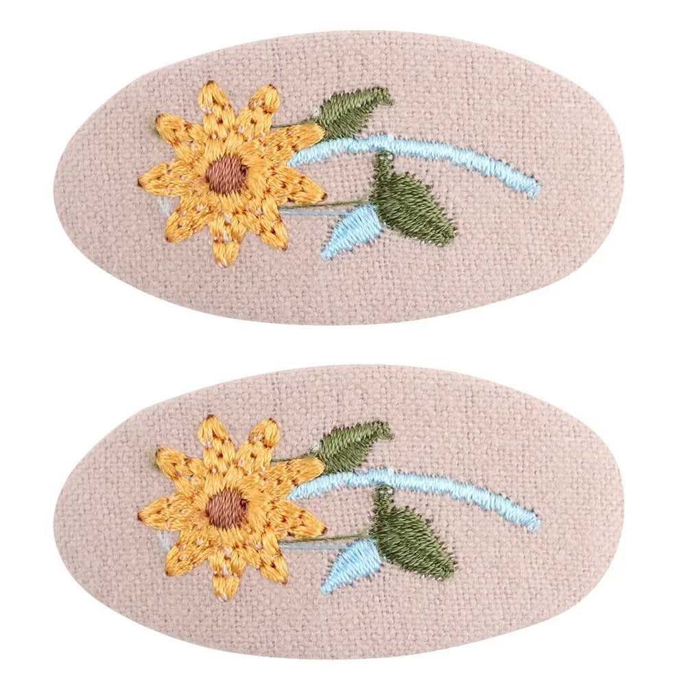 Overhead shot of two retro floral hair clips, simple yet elegant design