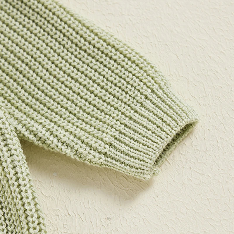 Close-up of knit texture on a unisex kids' cotton long sleeve sweater, cozy and soft.