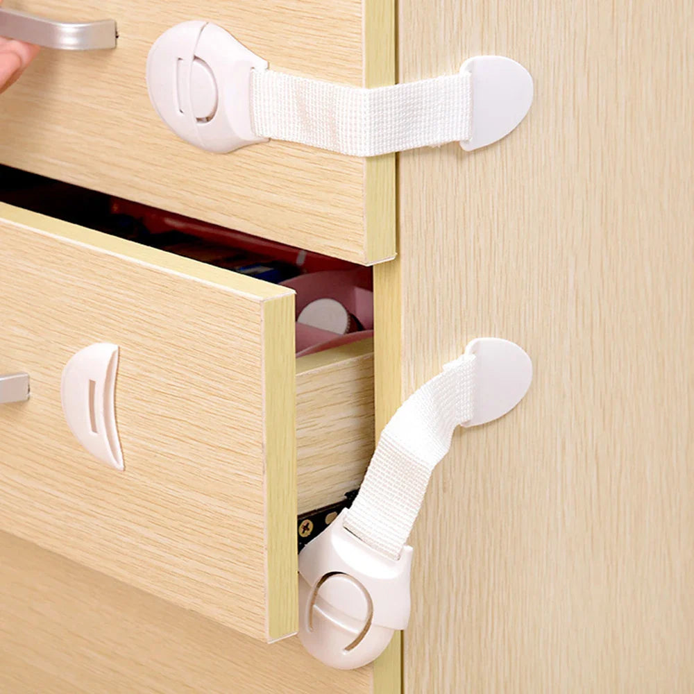 White ABS plastic childproof safety latches securing cabinet doors from toddlers