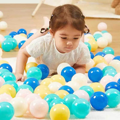 Child reaching into a ball pit filled with 200 colorful, durable play pit balls for kids' fun.