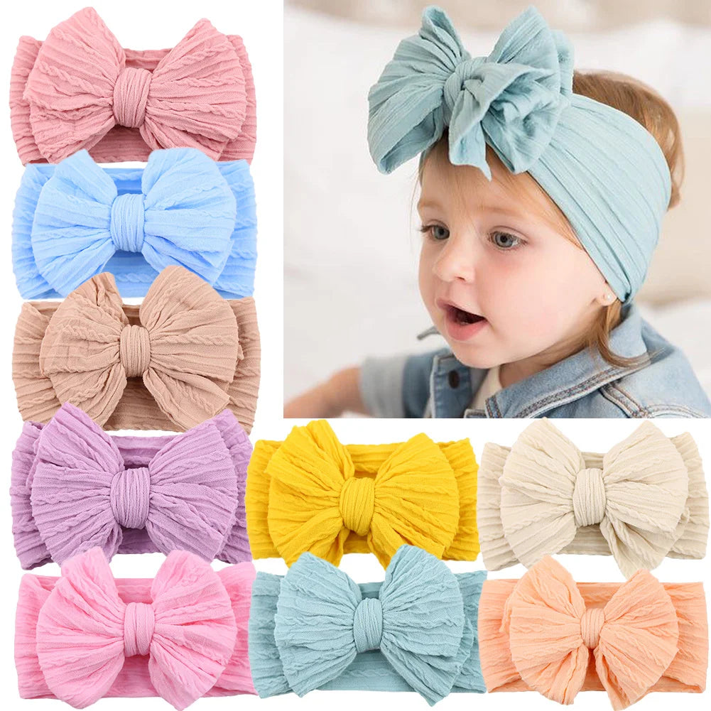 Stack of soft stretchy infant headbands with cable knit bows, great baby girl gifts
