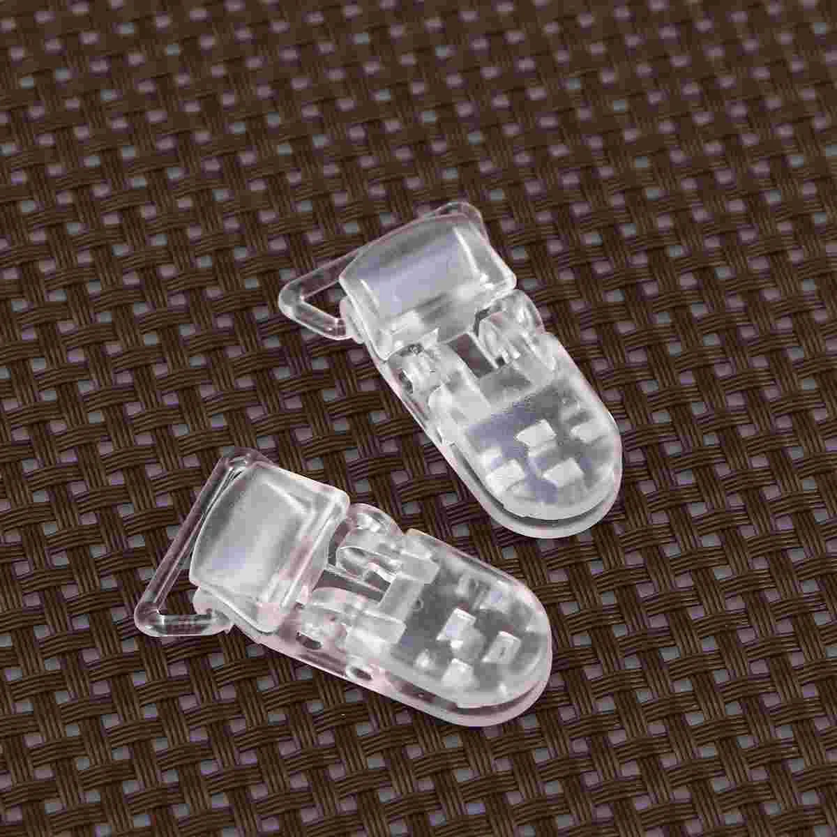 Close-up of clear T-shaped plastic craft clips, ideal for DIY pacifier holders