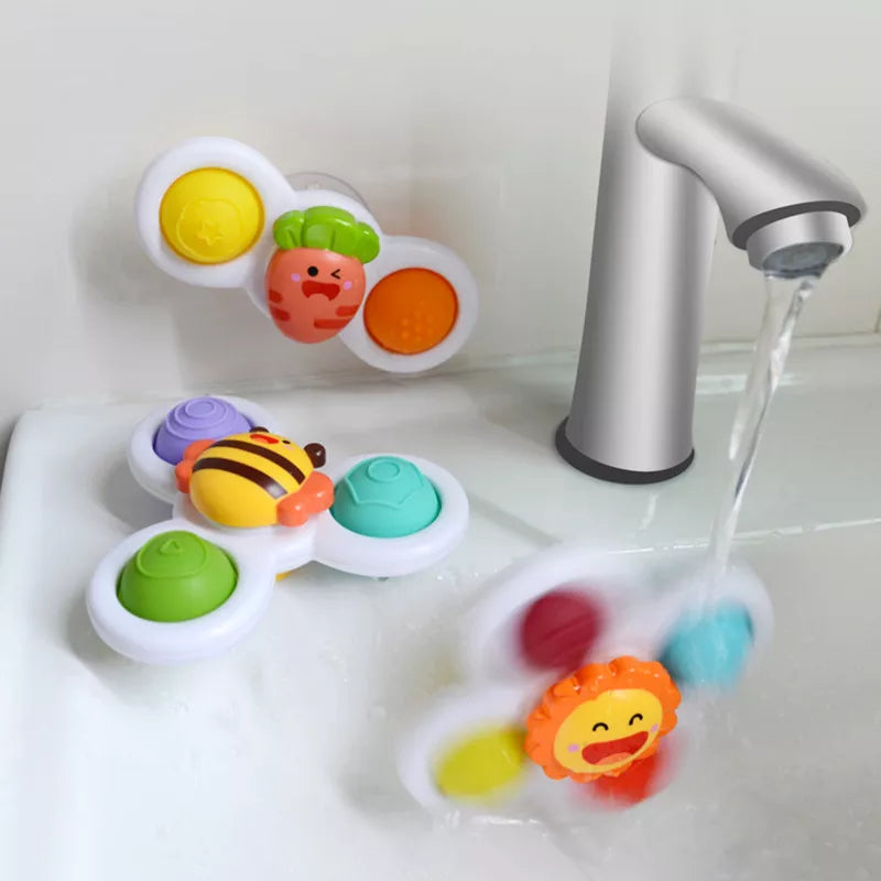 Assorted infant spinning tops with suction cups on a playmat, great for developmental play