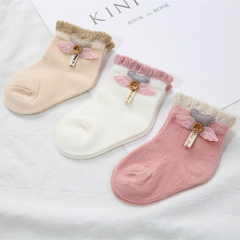 Close-up of a white baby's cotton newborn sock, showing the soft texture and stitching.