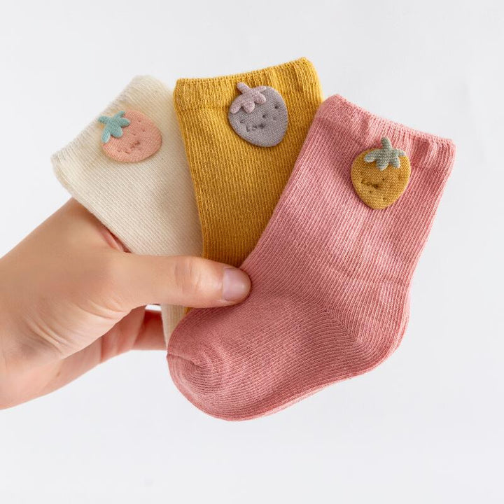 Cute socks for infants: a set of three cotton baby socks in blue, pink, and white.