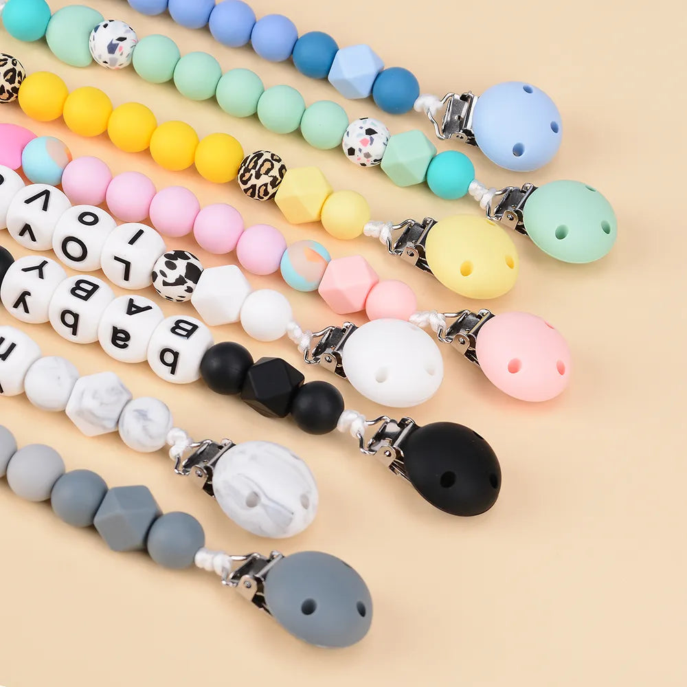 Five BPA-free silicone round pacifier clips, designed for safety and ease of use with infants.