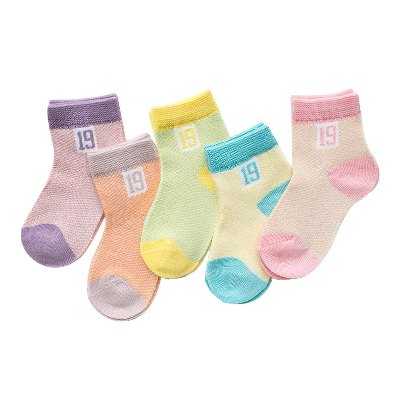 Close-up of the elastic cuff on a white cotton mesh baby sock, secure fit newborn