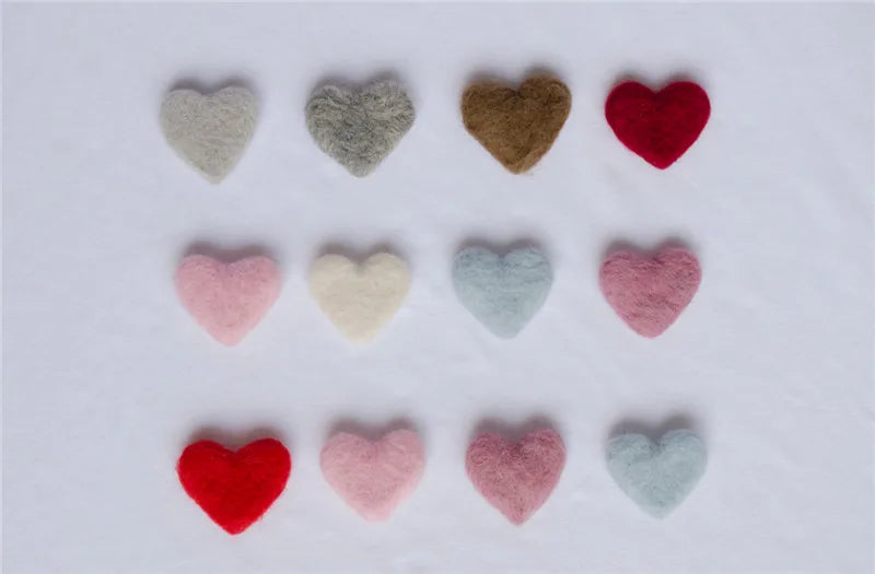 Close-up of a red wool love heart prop, highlighting its texture for newborn photography