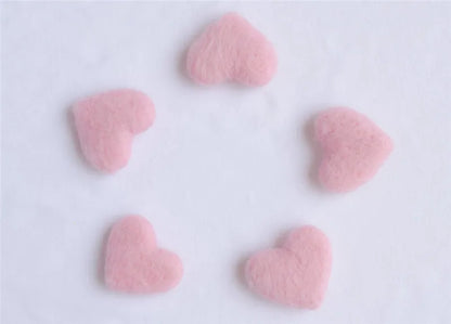Soft focus image of newborn baby photography props, emphasizing the wool love heart details
