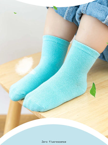 Hand holding a pair of soft anti-slip cotton socks, highlighting the quality of the material