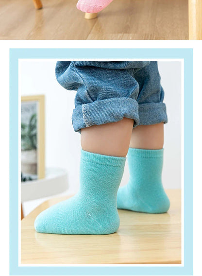 Display of various kids anti-slip cotton socks patterns: stripes, dots, animals, non-skid apparel