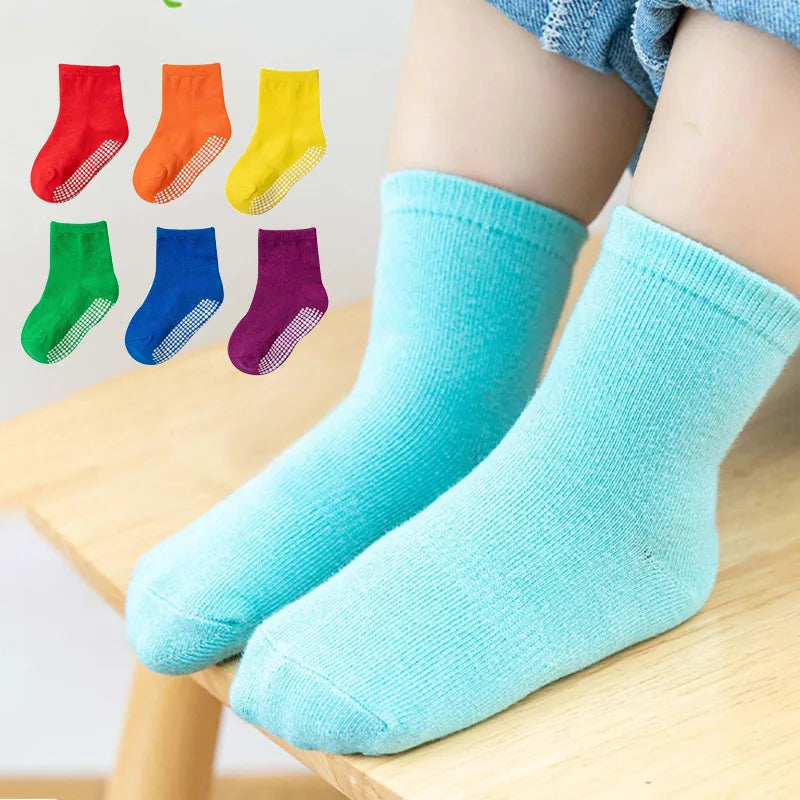 Child's foot in a brightly colored anti-slip cotton sock, ideal for active spring & autumn play