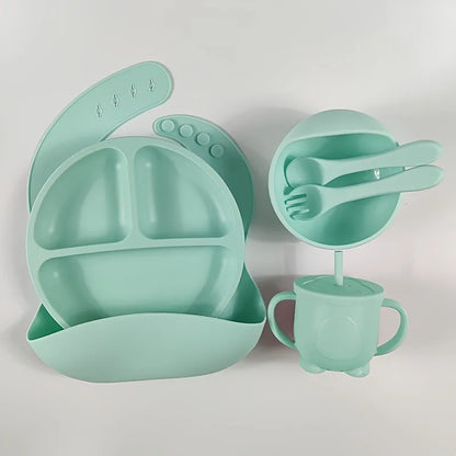 Practical children's weaning set: adjustable silicone bib, divided plate, bowl, cup, and silicone-tipped spoon and fork.