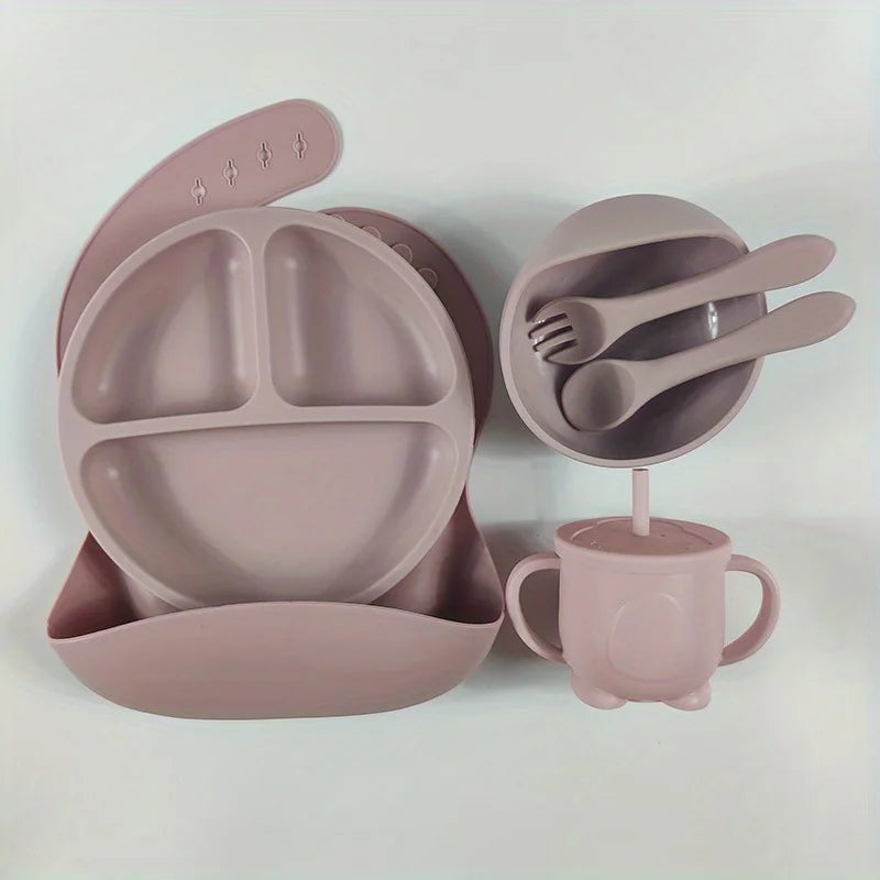 Giftable silicone feeding set for babies: includes suction plate, bowl, cup, fork, spoon, and a waterproof bib.
