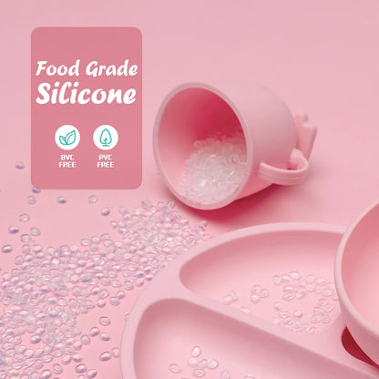 Kid-safe silicone feeding set featuring a green suction plate, bowl, spill-proof cup, and soft tipped utensils.