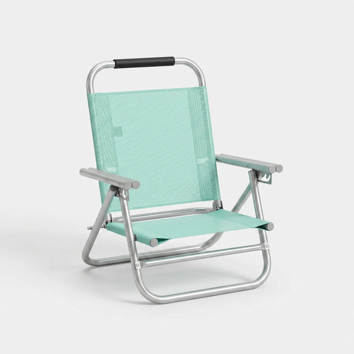 Portable folding beach chair with multiple recline positions, ideal for summer relaxation by the sea.