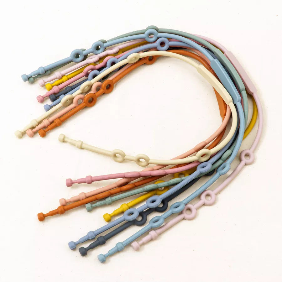 Variety of adjustable silicone pacifier clips in different textures and colors, essential baby feeding accessories