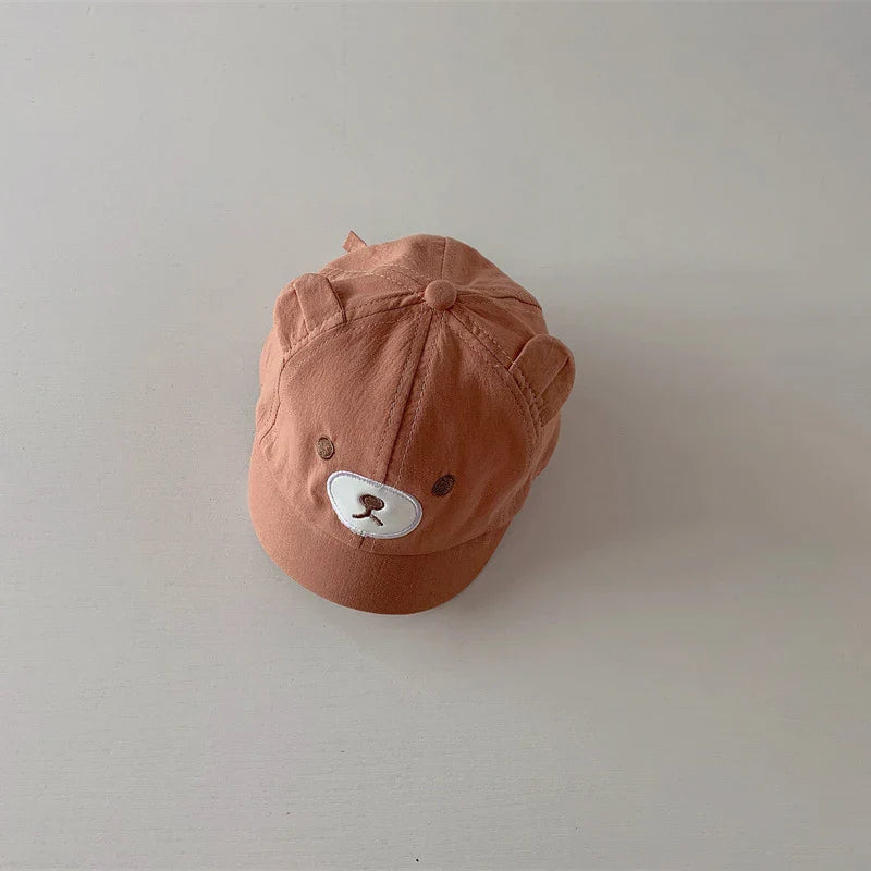 Child wearing a cute bear ears baseball cap, providing sun protection during outdoor play.