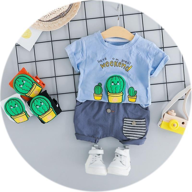 Adorable baby boy in a white cactus print short sleeve romper, perfect for summer playtime.