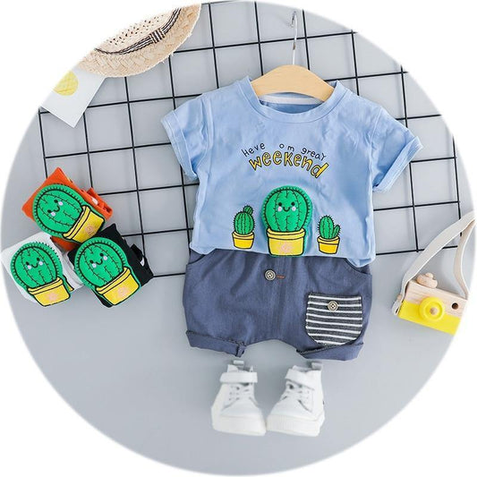 Adorable baby boy in a white cactus print short sleeve romper, perfect for summer playtime.