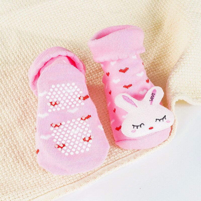 Front view of a single baby cartoon doll non-slip cotton sock, showcasing detailed design