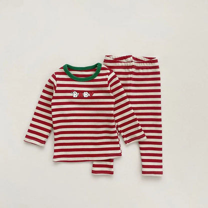 Red and white striped baby Christmas pajamas with a fun holiday design and an optional, cozy Santa hat.
